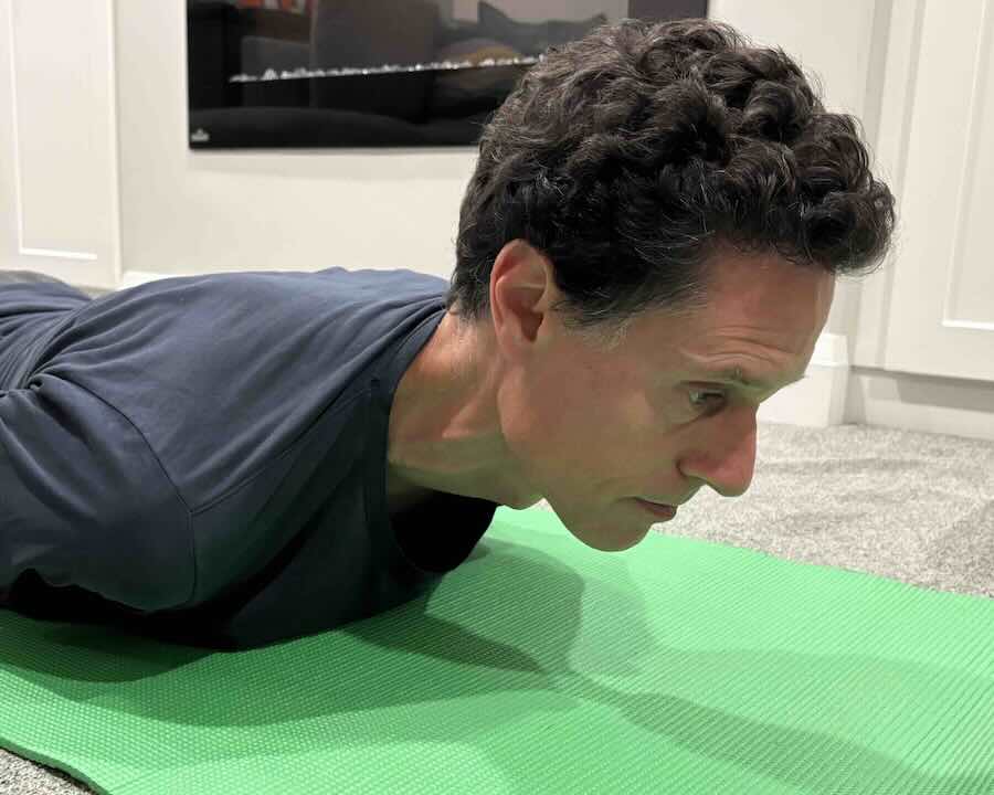 Patient performing chin tuck in prone position to align neck.
