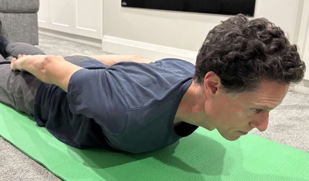 Chiropractor demonstrating neck and scapular retraction posture exercise.
