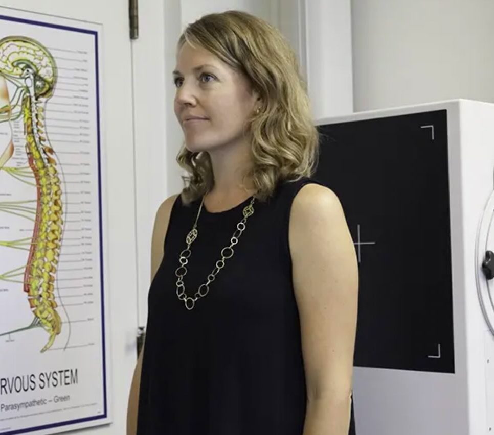 Chiropractor assessing posture alignment to identify imbalances affecting neck and back strain.