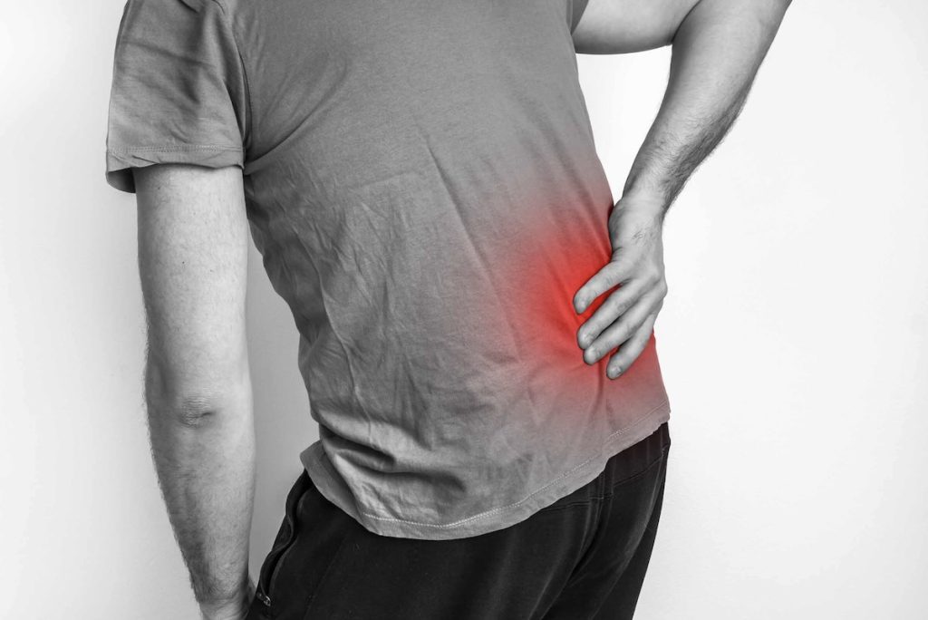 Person holding lower back in pain.