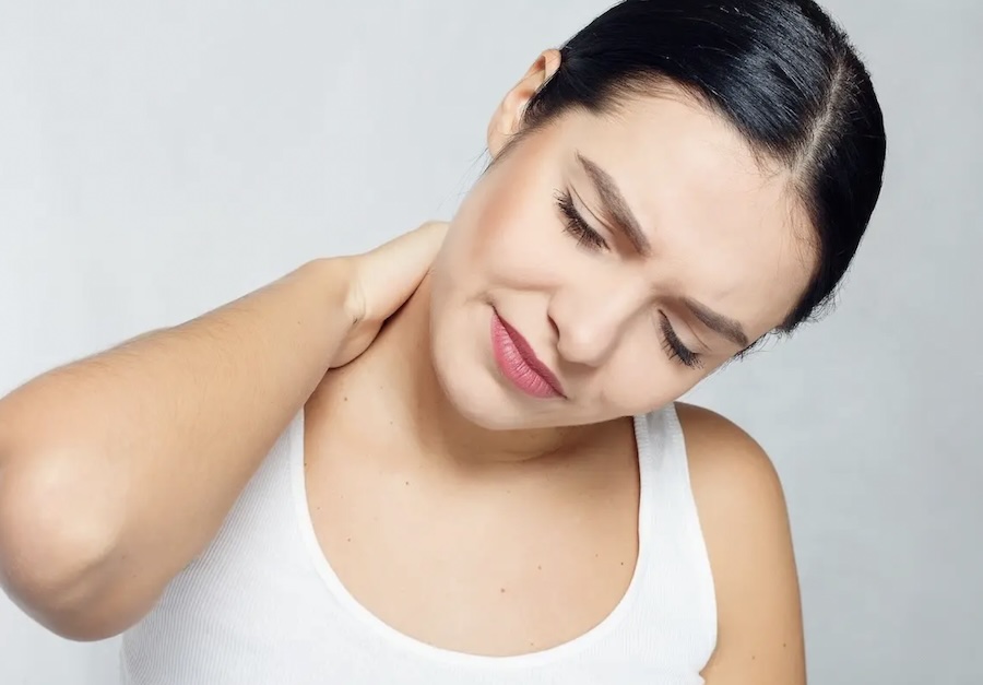 Woman rubbing the back of her neck due to tension headache caused by cervical strain.